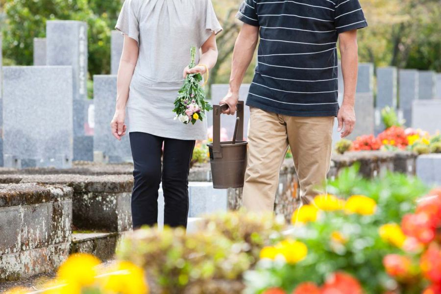 pareja poniendo flores en el cementerio